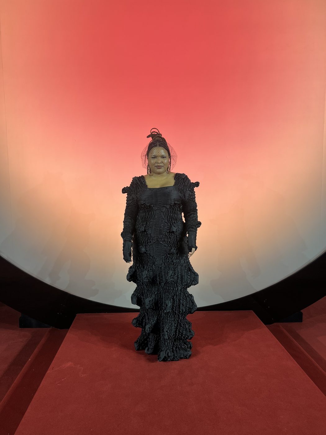 Karla Quiñonez León in a black ruffled gown with veiled headpiece